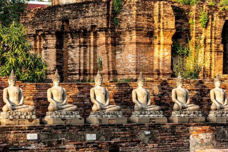 Row of Buddha statues on a stone wall