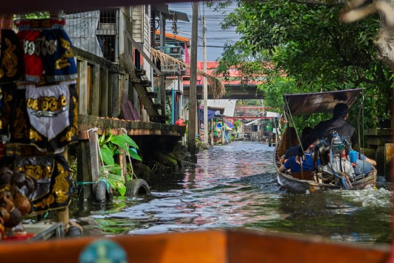 Boat on a narrow canal lined with shops