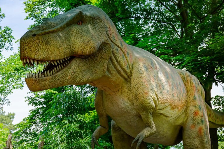 Dinosaur model in front of trees