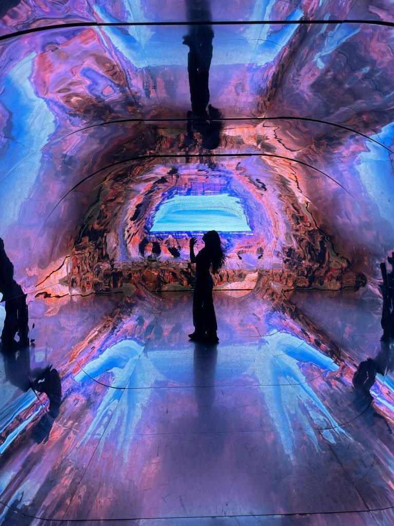 Visitor inside a colourful digital art installation