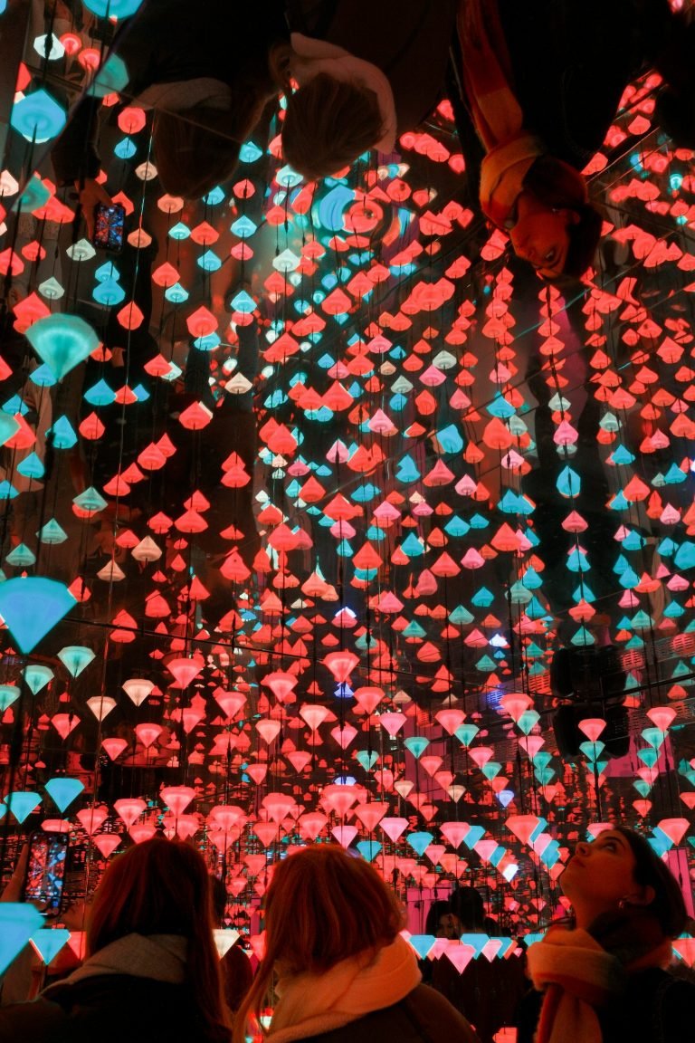 People looking up at a glowing light installation
