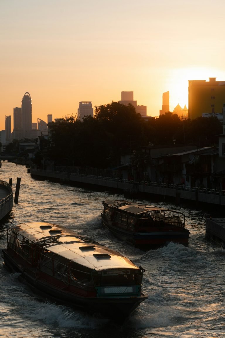 Boats on the river with the city skyline at sunset
