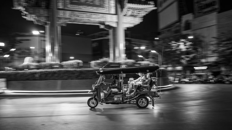 Tuk-tuk driving through the city at night
